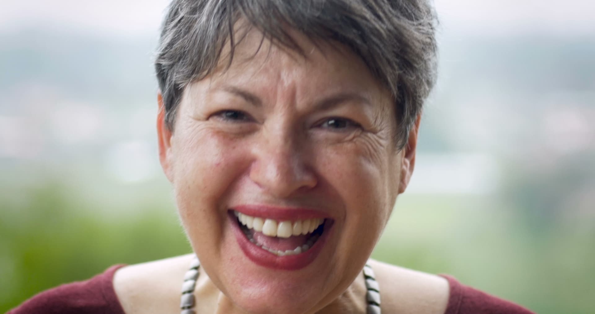 A vibrant woman in her sixties smiling confidently